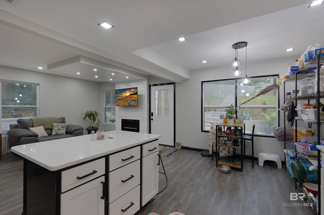 kitchen with a wealth of natural light, a center island, dark wood-type flooring, and white cabinets