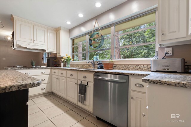 kitchen featuring stone counters, white cabinets, sink, light tile patterned floors, and stainless steel dishwasher