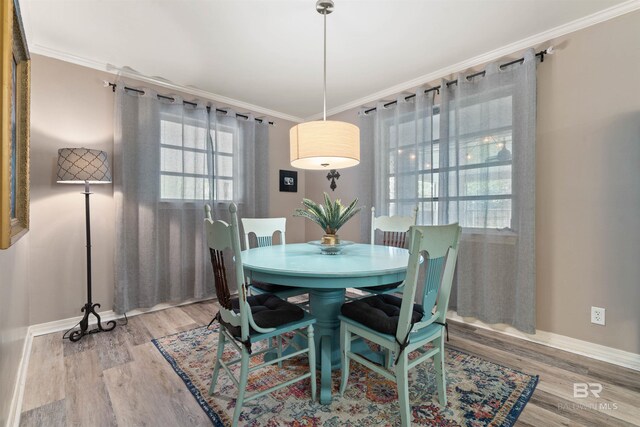 dining area featuring hardwood / wood-style flooring and ornamental molding