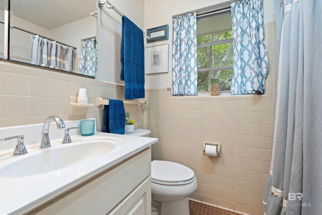 bathroom with vanity, tile patterned floors, tile walls, toilet, and backsplash