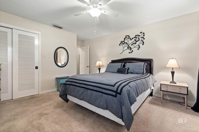 bedroom with light carpet, ceiling fan, and a closet