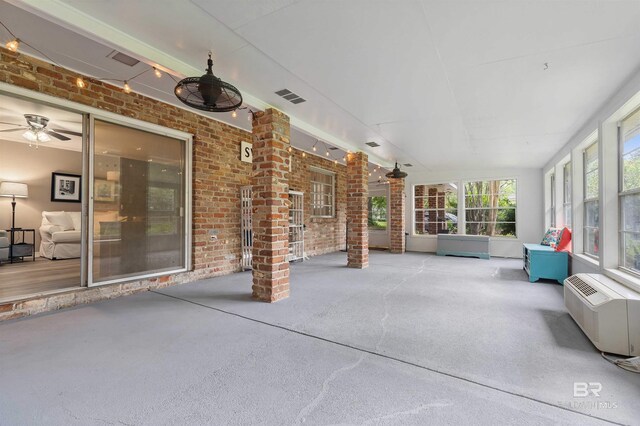 unfurnished sunroom with ceiling fan