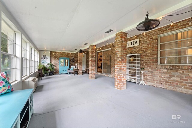 unfurnished sunroom with decorative columns