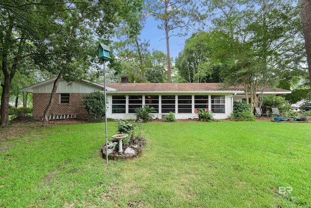 rear view of house featuring a lawn