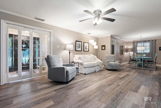 living room with hardwood / wood-style flooring, french doors, ornamental molding, and ceiling fan