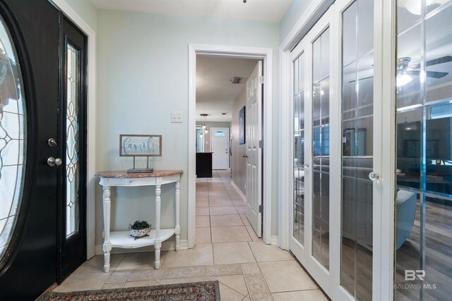 hall with french doors and light tile patterned floors