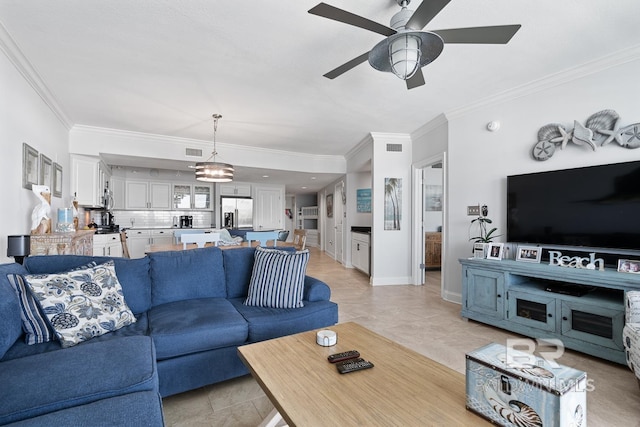 living room with ceiling fan with notable chandelier, crown molding, and light tile floors