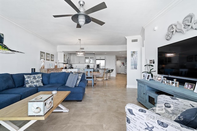 tiled living room with ceiling fan and crown molding