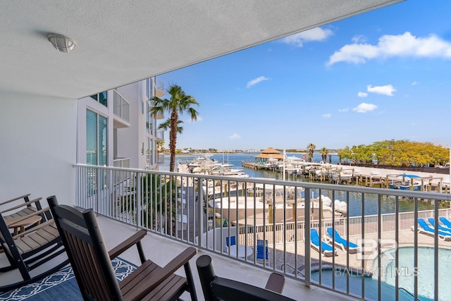 balcony featuring a water view and a community pool