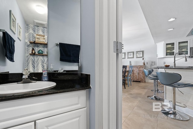 bathroom featuring ornamental molding, tile flooring, and vanity