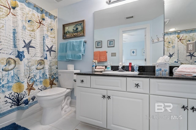 bathroom with tile flooring, vanity, and toilet