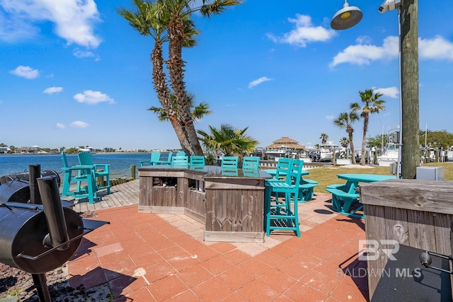 view of patio / terrace with a water view and exterior bar