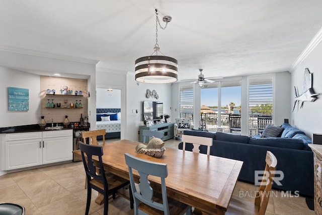 dining space with sink, ceiling fan, crown molding, and light tile floors