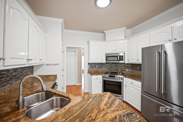 kitchen featuring crown molding, a sink, appliances with stainless steel finishes, and white cabinets