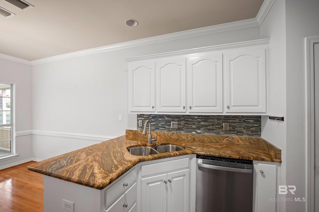 kitchen featuring white cabinets, a sink, dark stone counters, tasteful backsplash, and stainless steel dishwasher