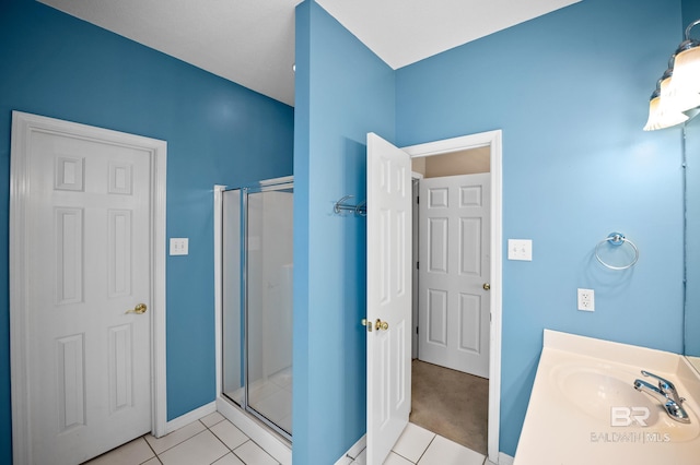 full bathroom with vanity, baseboards, tile patterned flooring, and a shower stall