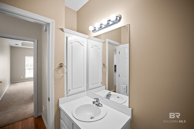 bathroom with vanity, baseboards, and wood finished floors