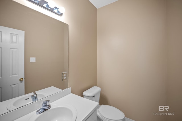 half bath featuring toilet and vanity