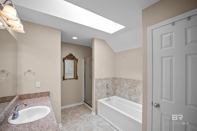 bathroom featuring vanity, baseboards, lofted ceiling with skylight, a bath, and a shower stall