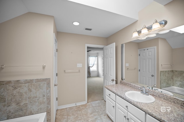 bathroom featuring visible vents, baseboards, a tub, and vanity