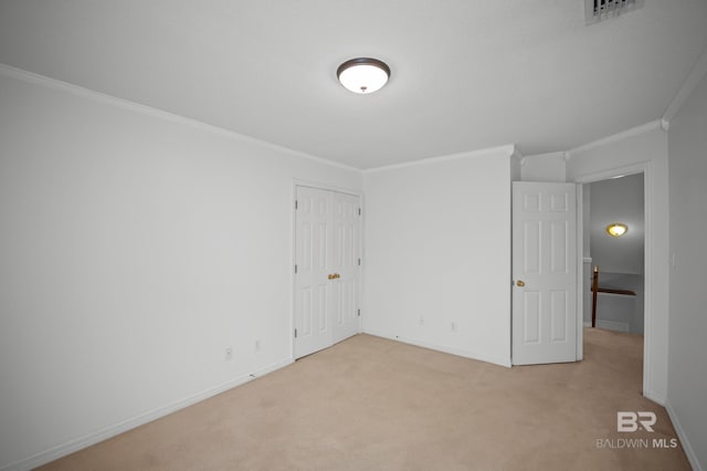 empty room featuring crown molding, baseboards, light carpet, and visible vents