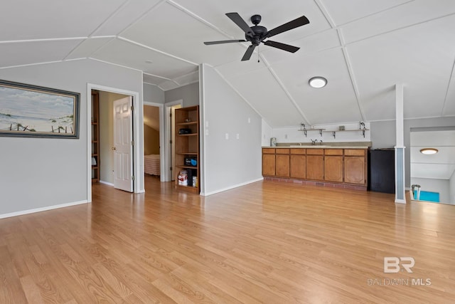 unfurnished living room with vaulted ceiling, ceiling fan, and light wood-type flooring