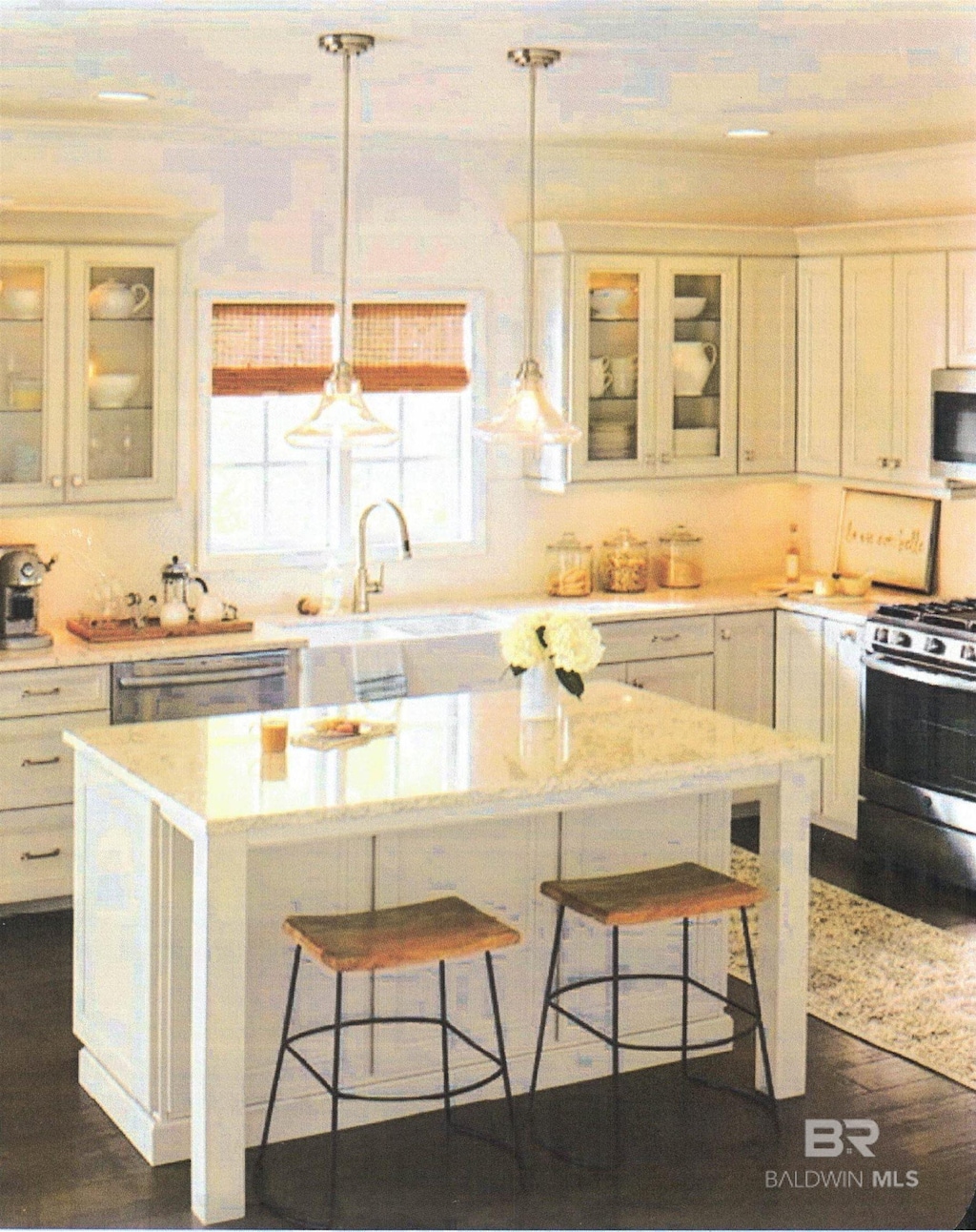 2721 Manuel Dr, Lillian, AL 36549 - kitchen featuring appliances with stainless steel finishes, a sink, a center island, a breakfast bar area, and glass insert cabinets
