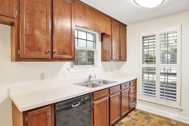 kitchen with a textured ceiling, dishwasher, and sink