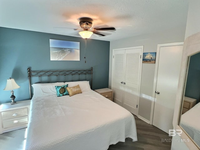 bedroom with a closet, a textured ceiling, dark hardwood / wood-style floors, and ceiling fan