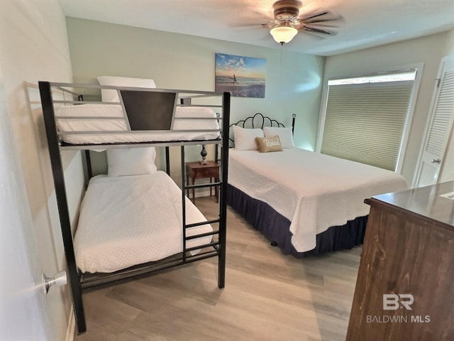 bedroom with hardwood / wood-style flooring, ceiling fan, and a closet