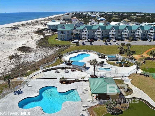 birds eye view of property featuring a water view and a beach view