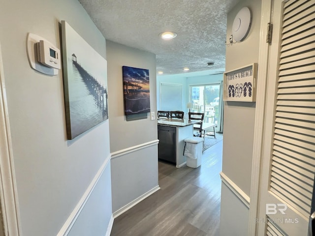 corridor with dark hardwood / wood-style floors and a textured ceiling