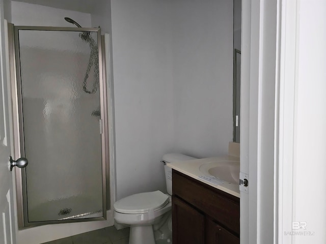 bathroom with tile patterned floors, vanity, toilet, and a shower with shower door