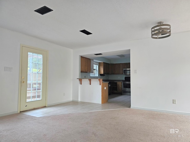 unfurnished living room featuring light carpet