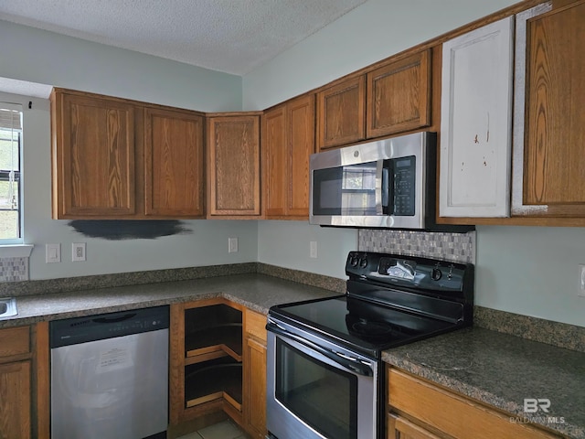 kitchen featuring a textured ceiling, stainless steel appliances, and light tile patterned flooring