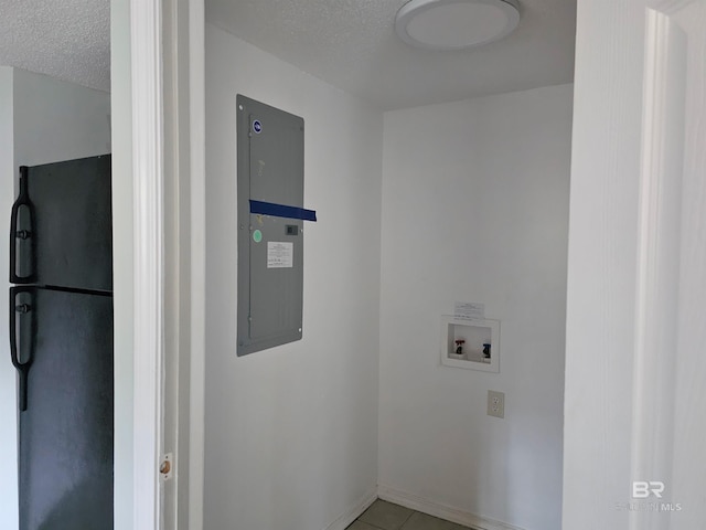 clothes washing area featuring washer hookup, light tile patterned flooring, a textured ceiling, and electric panel