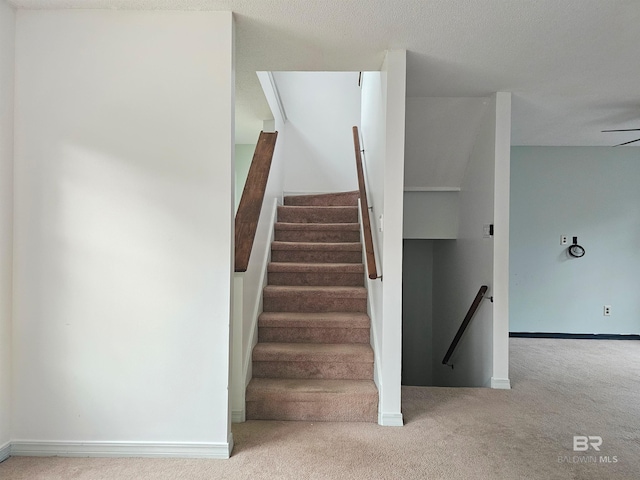 stairs featuring carpet flooring and ceiling fan