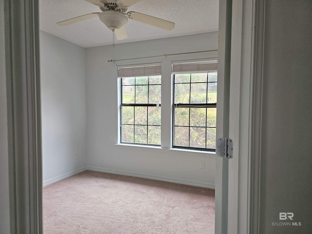 carpeted empty room featuring a textured ceiling and ceiling fan