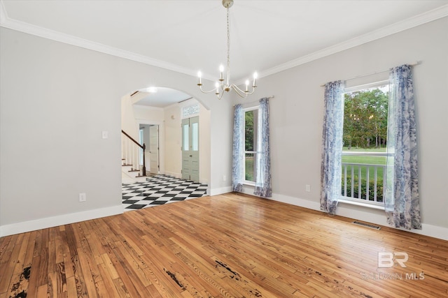 unfurnished room featuring light hardwood / wood-style flooring, ornamental molding, and a notable chandelier