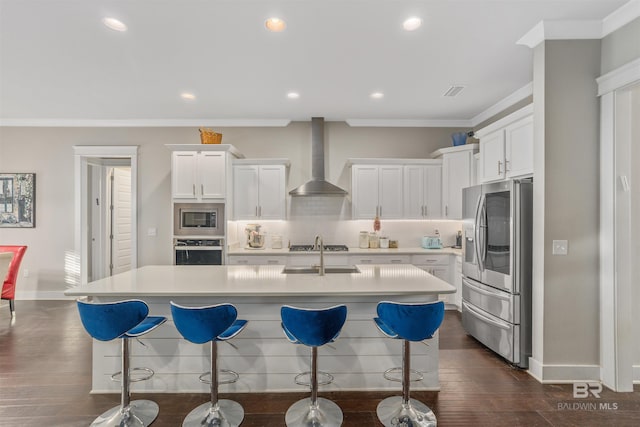 kitchen featuring backsplash, wall chimney range hood, light countertops, stainless steel appliances, and white cabinetry