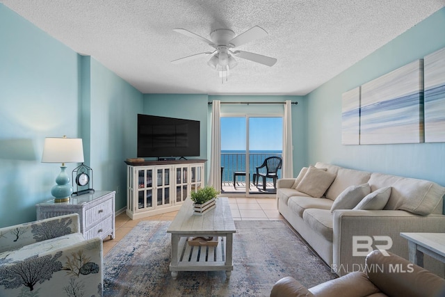 living room featuring tile patterned floors, a textured ceiling, and a ceiling fan