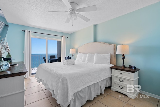 bedroom with ceiling fan, access to exterior, light tile patterned floors, and a textured ceiling