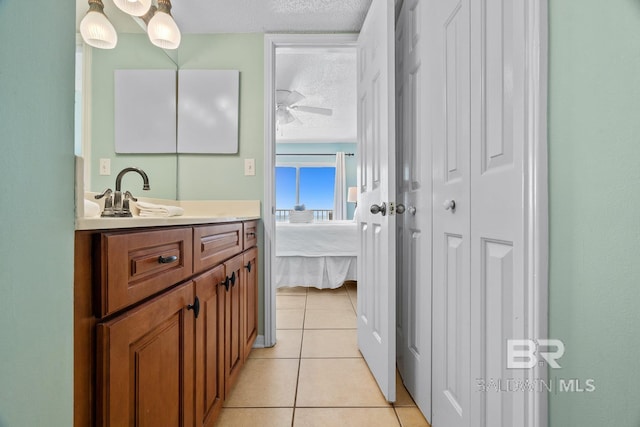 bathroom featuring vanity, ensuite bath, ceiling fan, a textured ceiling, and tile patterned floors