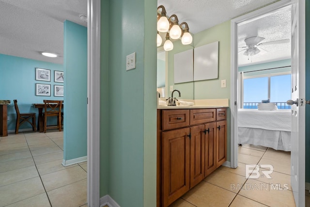 ensuite bathroom with ensuite bath, a ceiling fan, tile patterned floors, and a textured ceiling