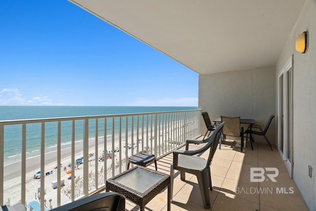 balcony featuring a beach view and a water view