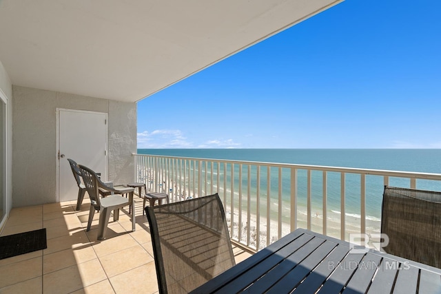 balcony with a water view and a view of the beach