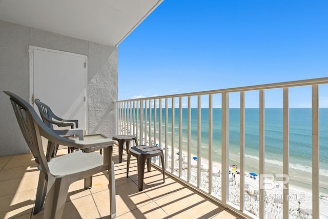 balcony featuring a water view and a beach view