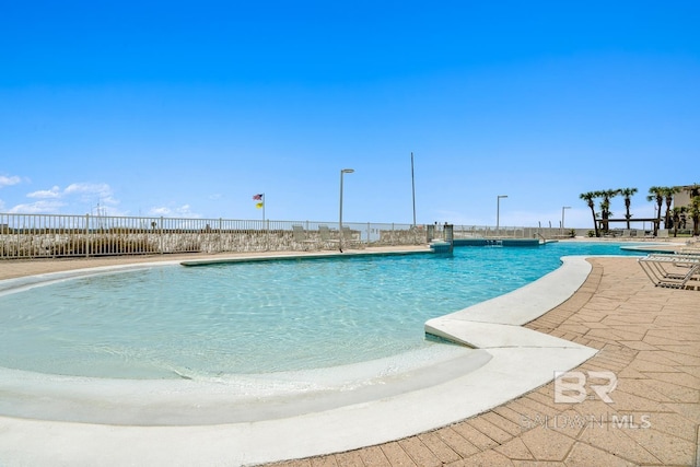 pool with a patio and fence