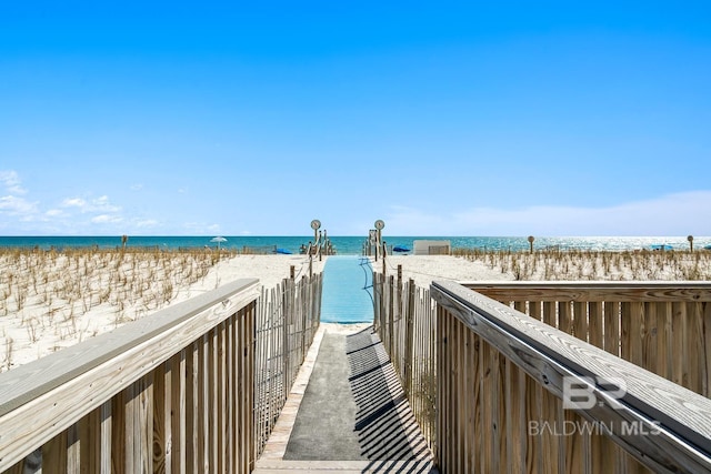 view of community featuring a water view and a beach view