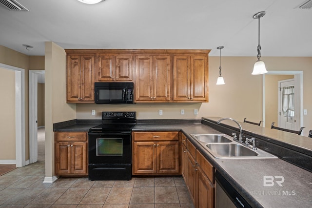 kitchen featuring black appliances, a sink, brown cabinets, and dark countertops